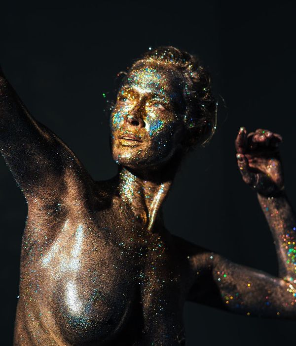 Woman in a dynamic yoga pose, studio lighting highlighting her form.